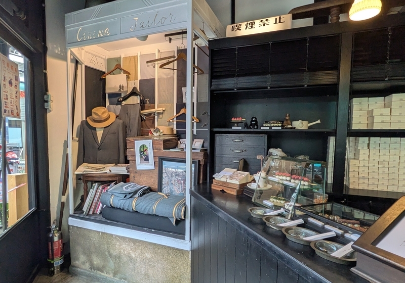 店内には仕立て関連の展示が並び、手前には串団子を提供するカウンターが設けられている。