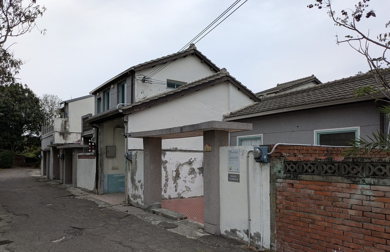 奥の道路沿いに続く眷村住宅の街並み。