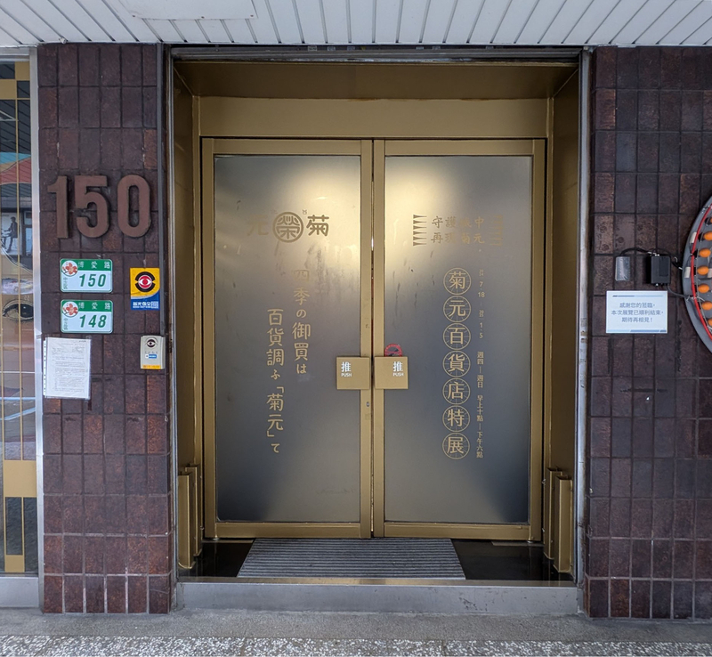 通用入口のドア。当時の文字やこの百貨店の特別展示の案内が残されている。