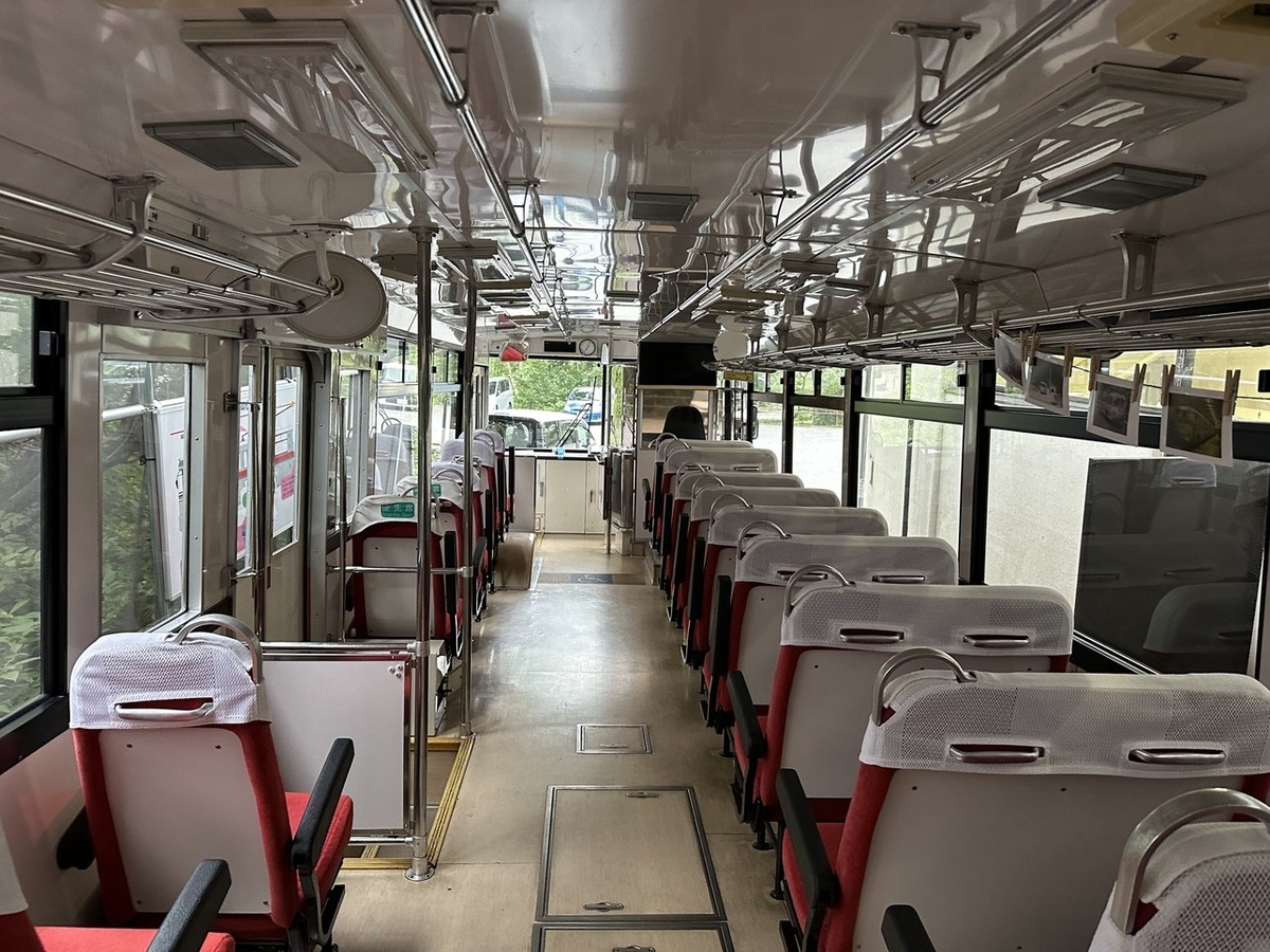 バスの車内。右に2列、左に1列の赤い座席がある。