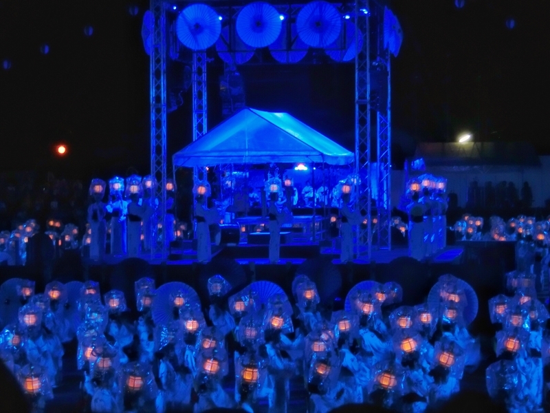 千人灯籠踊りの最中に雨が降ってきたため、灯籠にビニールを被せて踊っている様子