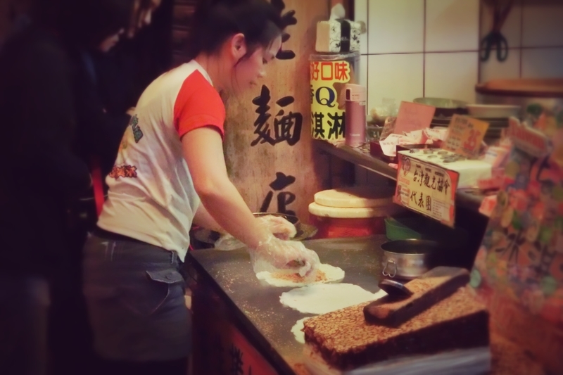 九份（きゅうふん）の屋台で客に売る飲食物を作っている女性