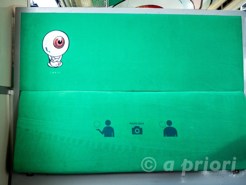 目玉おやじでラッピングされた鬼太郎列車の車内の座席。目玉おやじの絵が描かれている