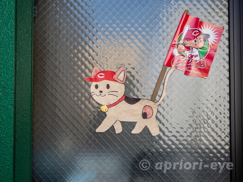 尾道本通り商店街のガラスに貼られたカープの帽子をかぶった猫の張り紙