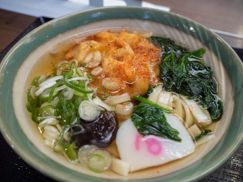 宮きしめんの天ぷらとわかめ、ナルト、ネギが盛られたきしめん