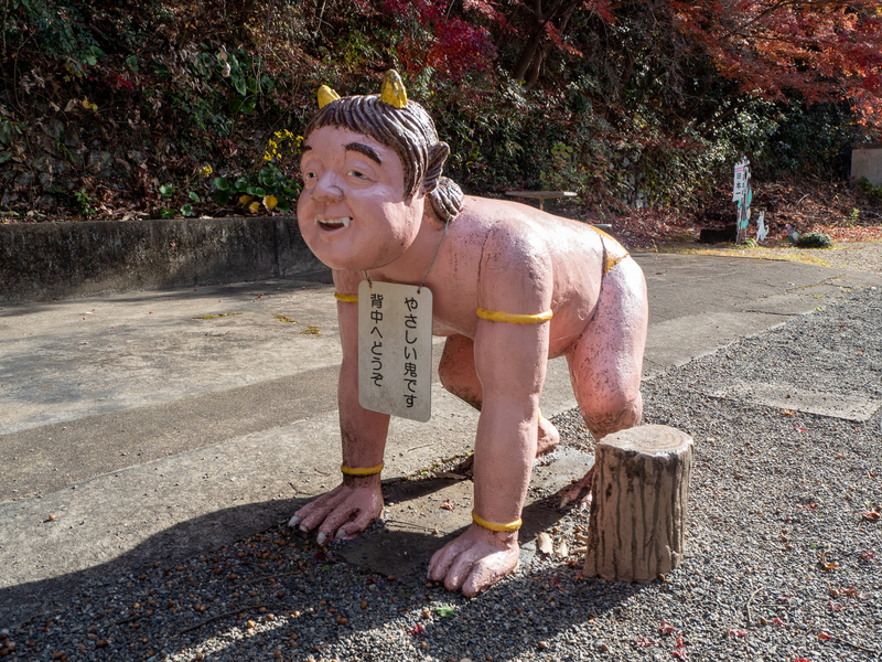 犬山市にある桃太郎神社に展示されている鬼の人形。四つん這いになり「やさしい鬼です。背中へどうぞ」と書かれた板を首からぶら下げている