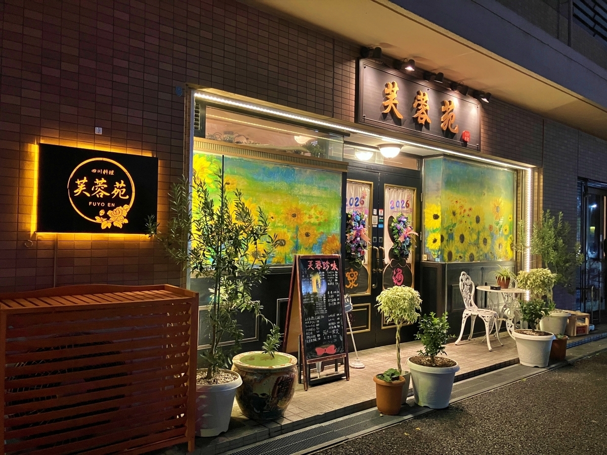 店の看板以外の置かれた椅子や植物が洋風な店構え