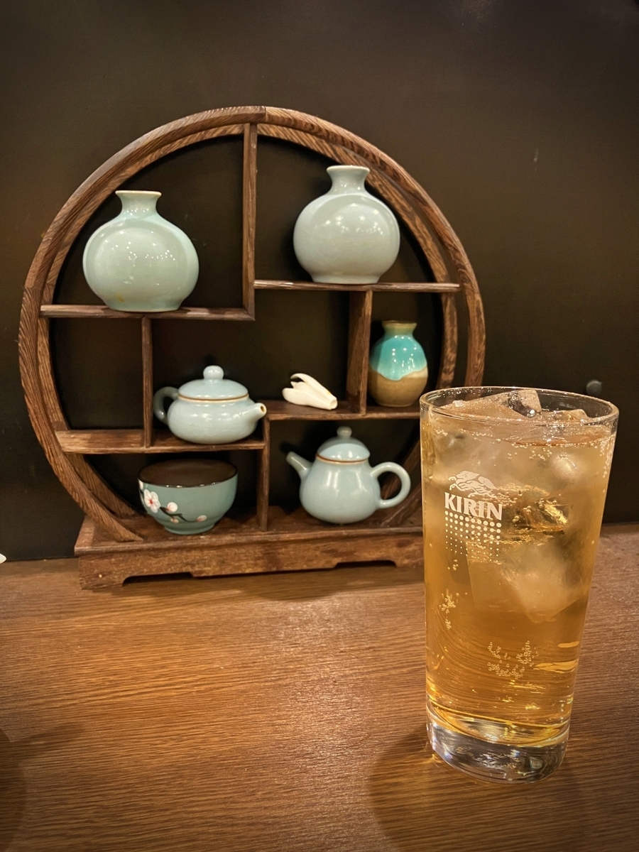 ジンジャーエールのグラスと飾り棚に配置された小ぶりの茶器