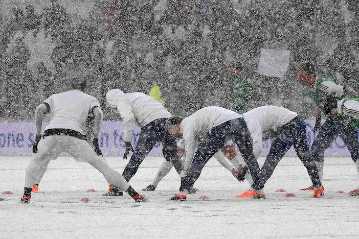 画像：大雪の中でアップをする選手たち