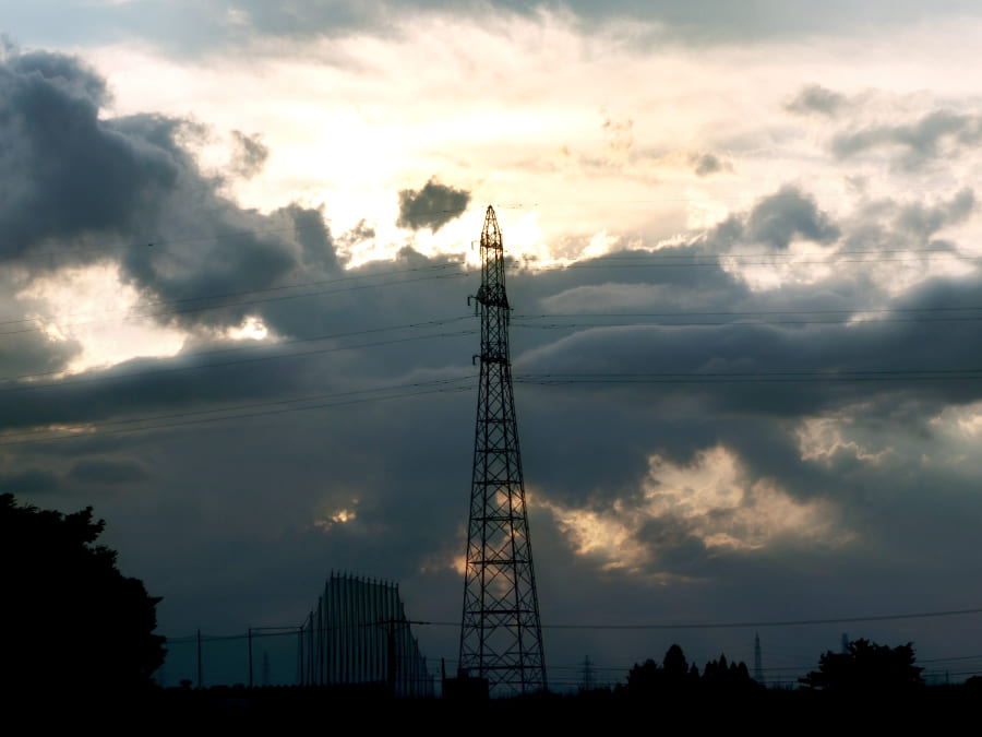 広角の写真撮影 ほの暗い雲から差す光と送電塔