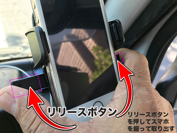 車載用スマホホルダーからスマホを取り出している画像