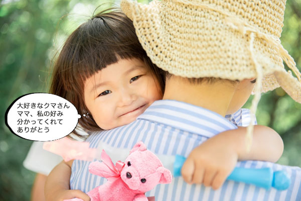 大好きなクマのぬいぐるみを持って抱っこされている子供