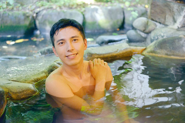 温泉に入って幸せを感じる男性