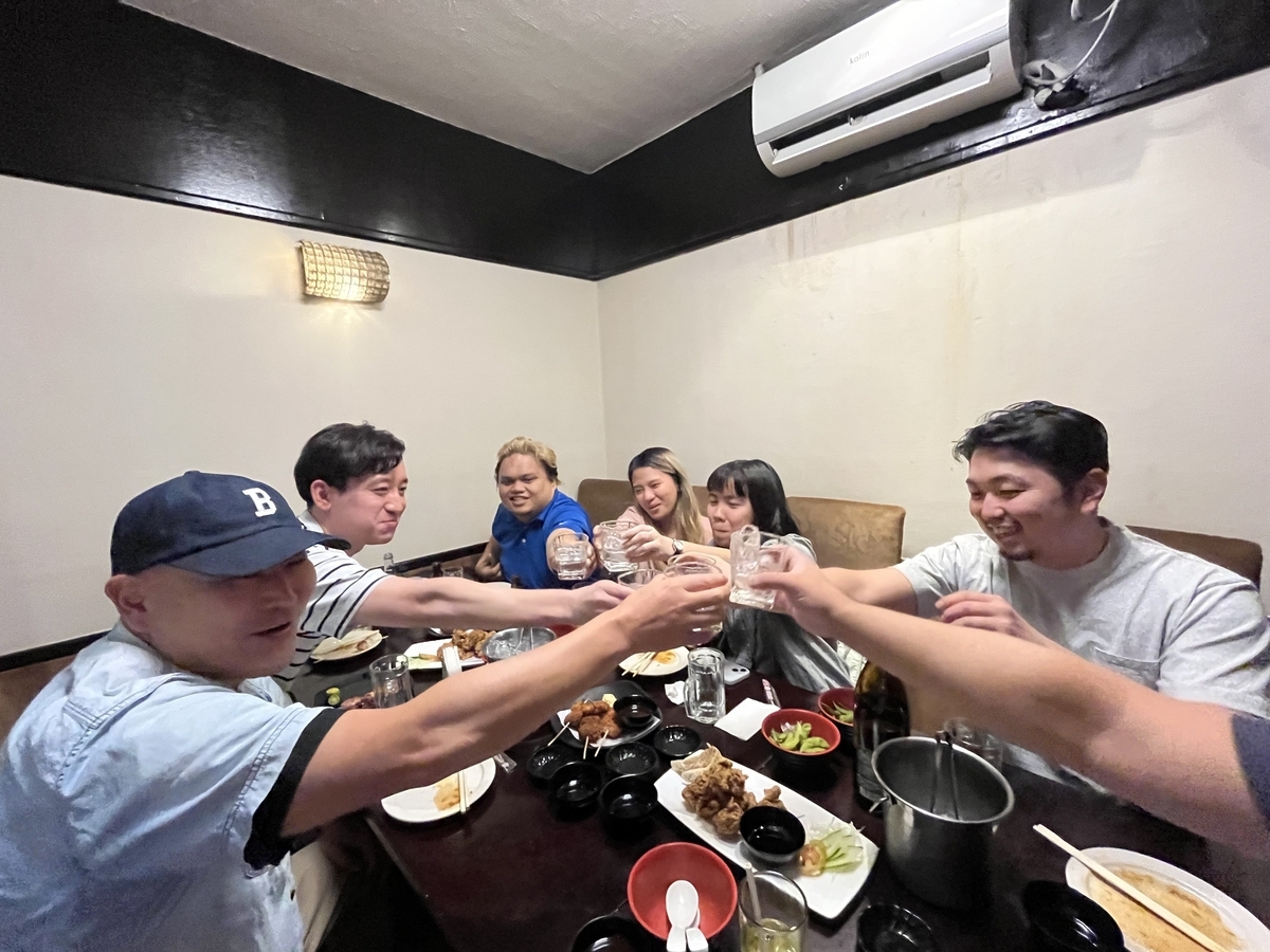 複数の現地メンバーと乾杯している画像