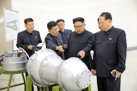 核開発計画について指示する金正恩委員長（右から２人目）とされる写真＝朝鮮中央通信・ロイター