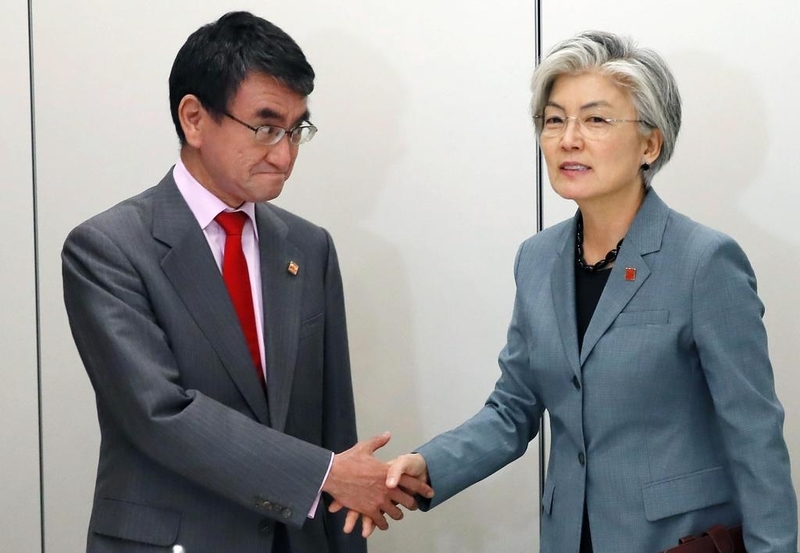 韓国の康京和外相(右)と握手する河野外相=23日、パリ(AP)