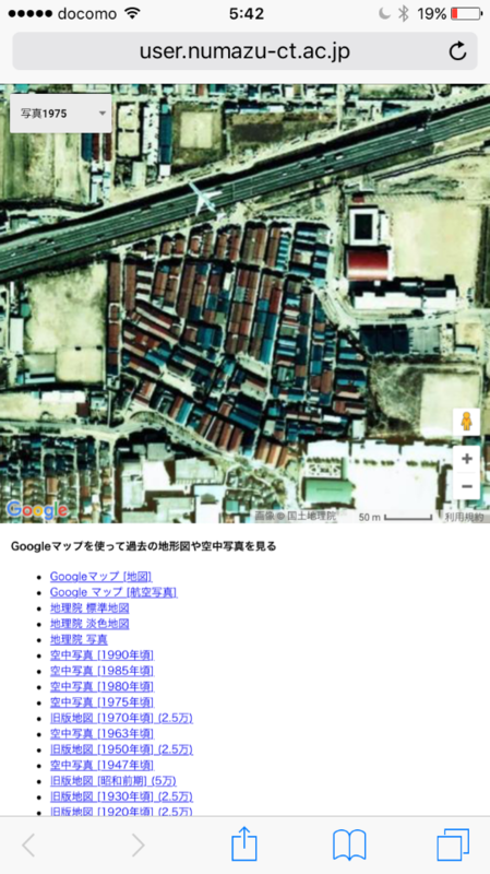 昭和50年(1975年)朝鮮人などが不法占拠した埋立地(空港敷地)に建てられた長屋(バラック)の「部落集落」の上を旅客機が低空飛行し、近くの高速道路で車が走っている。