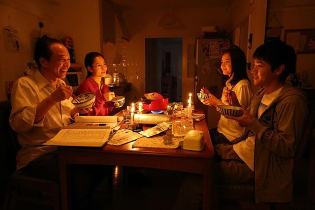 停電の中で、食卓を囲む鈴木一家の画像