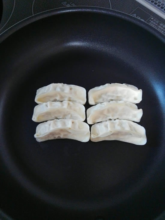 フライパンに6個の餃子を並べた写真