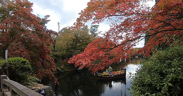 弘前公園の東内門前石橋から見たお堀に浮かぶ菊人形と紅葉の写真