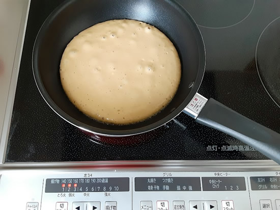 フライパンでホットケーキを焼いている写真