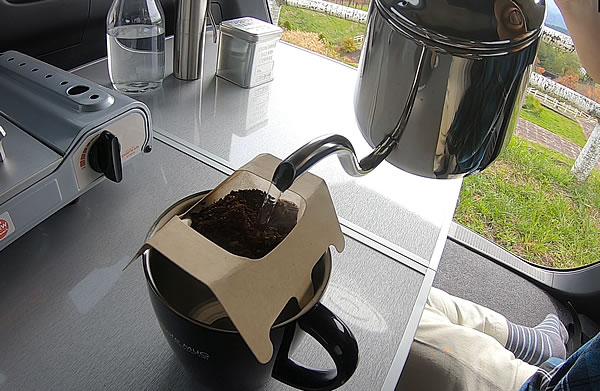 ポットでお湯を入れてコーヒーを淹れている写真