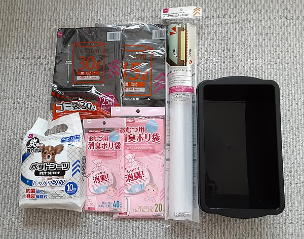 ダイソーで買ってきたコンテナBOX、ゴミ袋、消臭ポリ袋、ペットシーツ、ぶつかり防止クッションの写真