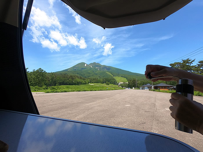 岩木山を背景にコーヒーミルで豆を挽く