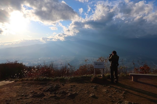 陣馬形山の山頂から写真を撮る登山者