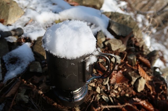 カップを使って雪を解かし水を作る様子