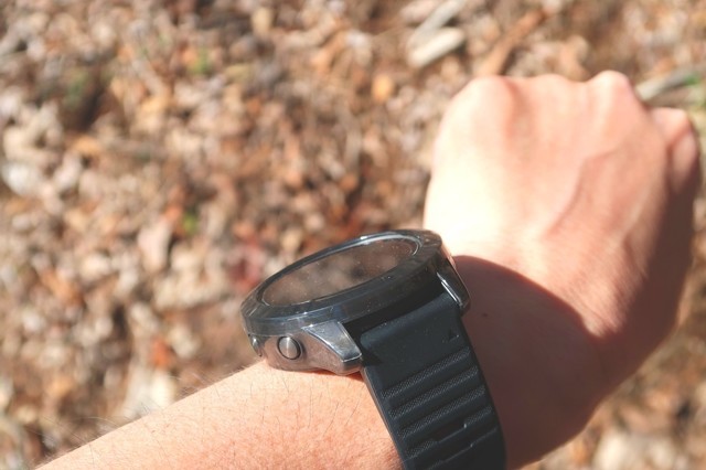 登山中に太陽光をソーラー腕時計に当てて充電している様子