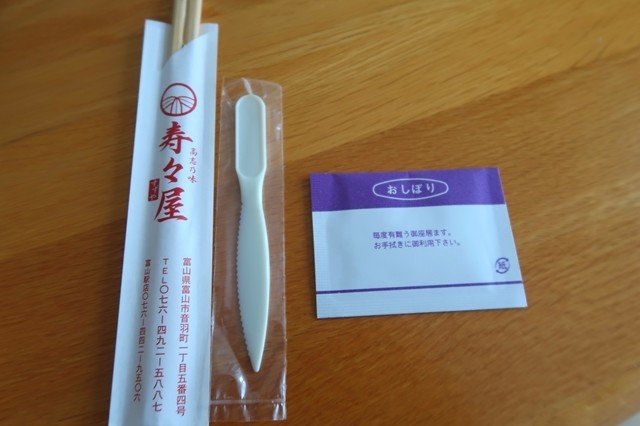 鱒のすしをカットすプラスチックのナイフとおしぼり、お箸