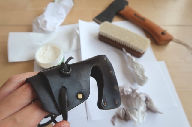 ハルタホース革製の斧カバーを磨いて掃除している様子