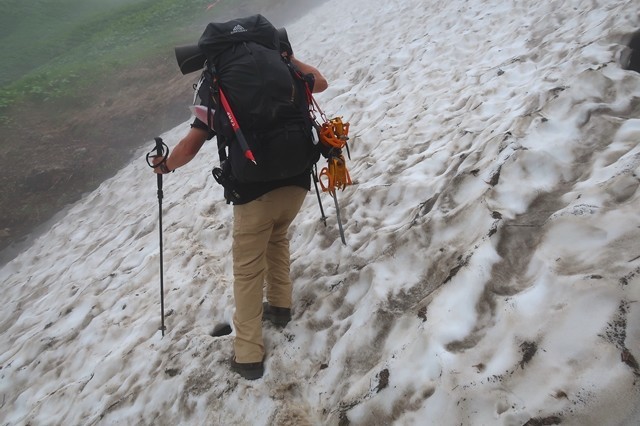 石転び沢雪渓の最大斜度を歩く登山者