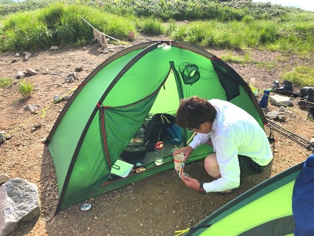 テント場で設営中の登山者