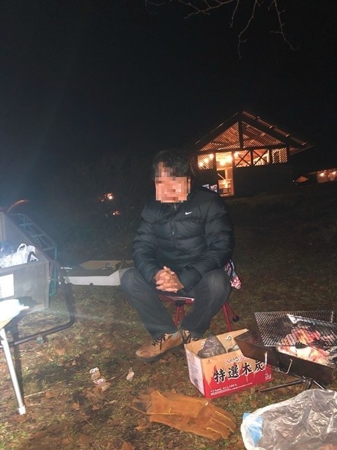 焚火で暖をとる男性キャンパー