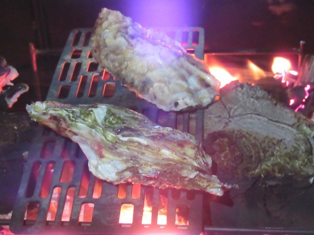 牡蠣を焚き火で焼いている様子