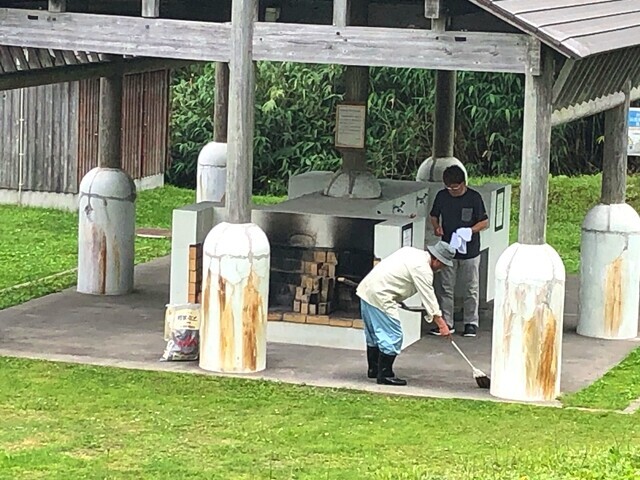 炊事場を掃除している管理人さんとキャンパー