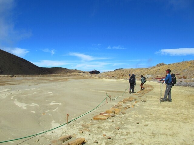 御嶽山二ノ池を眺める登山者