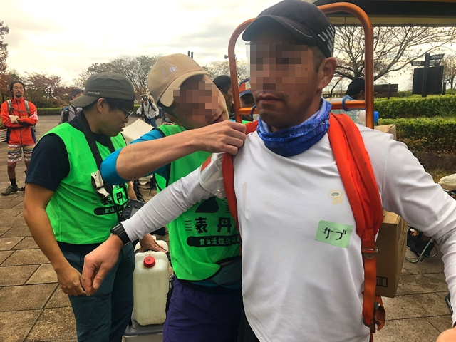 重い荷物を背負っている登山者