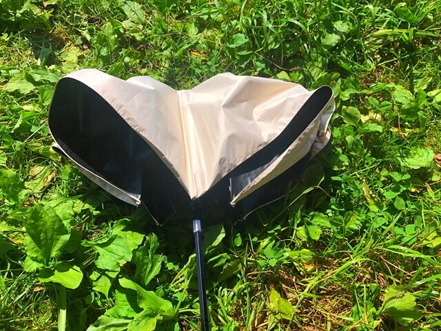 炎天下のキャンプ場で男性用日傘を使ってレビュー中の様子