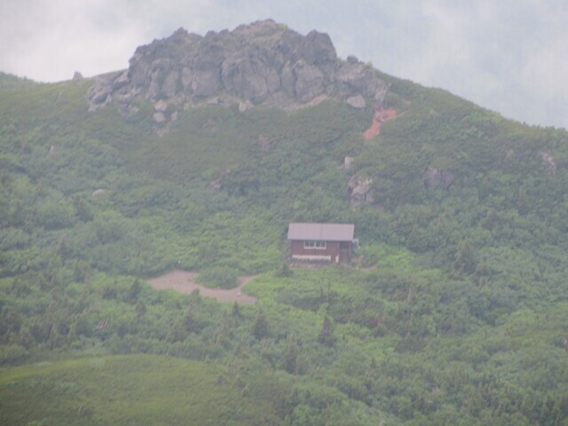 岩手山の山頂から遠くに不動平避難小屋の景色が見えた