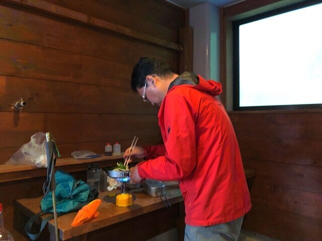 白根御池小屋で夕飯の調理を開始した登山仲間