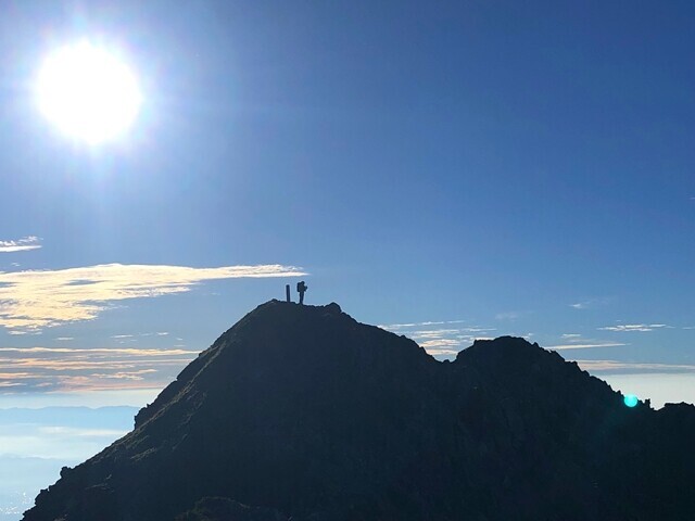 西農鳥岳の山頂で佇む女性登山者