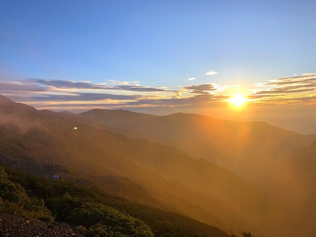 朝日に包まれる鳳凰三山の景色を農鳥小屋から遠望の様子