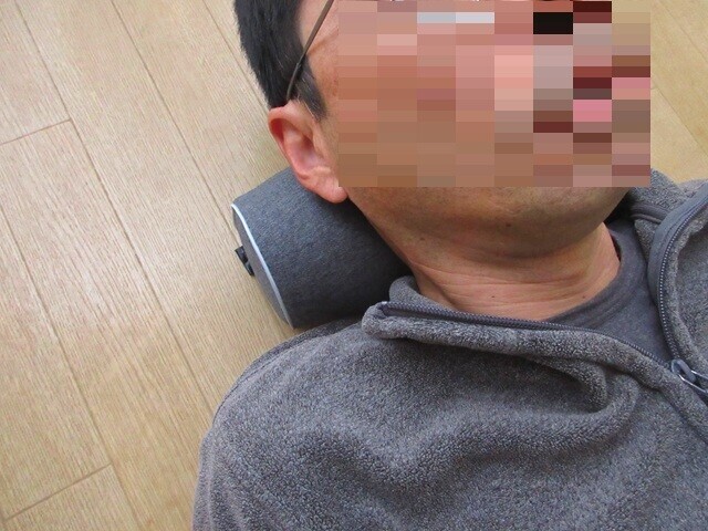 ネックピローを使って首のストレッチをしている様子