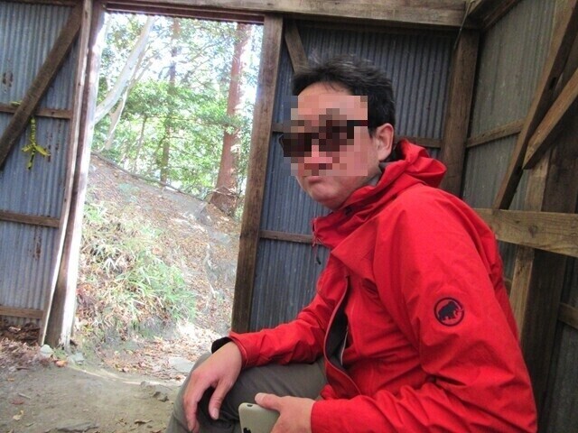 入道ヶ岳北尾根避難小屋で休憩する男性