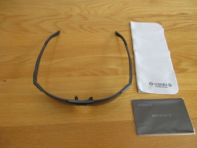 偏光サングラスとメンテナンス用の眼鏡ふき、偏光テストカードが付属している様子