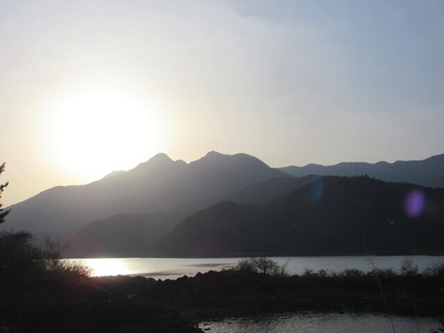 夕日に沈む河口湖越しの十二ヶ岳方面をテントサイトから望む