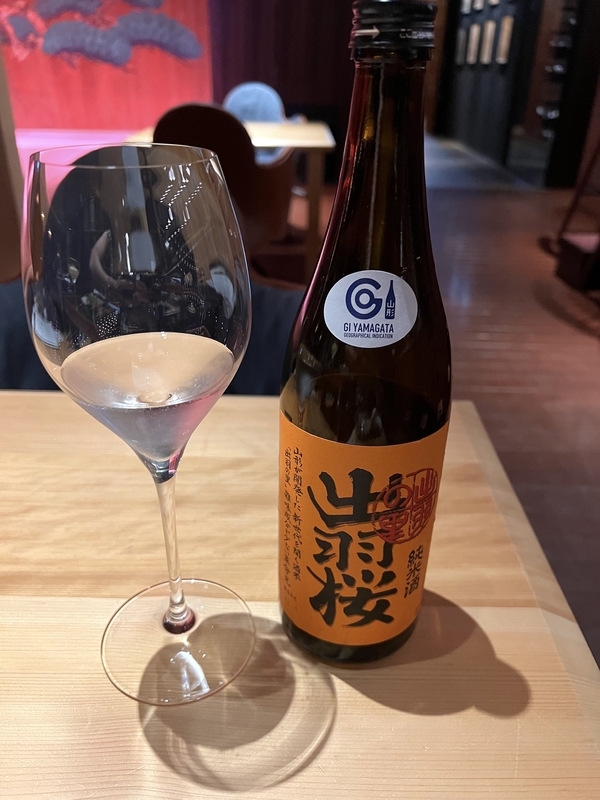 日本酒「出羽桜」のボトルとグラスに注がれた酒の写真